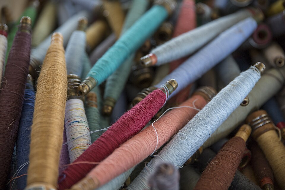 Carretéis de linha de várias cores, vistos de perto